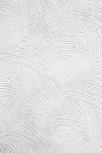 Abstract textured white plaster wall with artistic swirl patterns creating a subtle and elegant design.