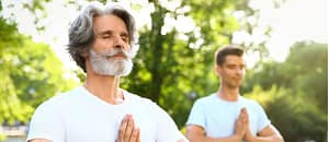 A couple of men standing in a park doing Qigong