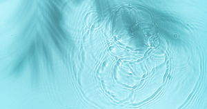 Close-up view of tranquil water ripples in a teal blue pond, symbolizing the calming source energy of Hun Yuan Chi. This image captures the essence of stillness and flow, reflecting the principles of Wisdom Healing Qigong and sound healing in its serene water patterns.