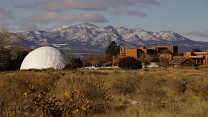 The Chi Center dome and buildings with mountains in the background.