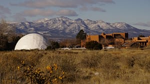 The Chi Center dome and buildings with mountains in the background.