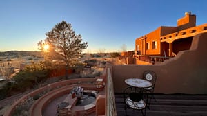 Serene sunrise view at a Southwestern-style retreat with adobe architecture, outdoor seating, and natural landscaping, capturing the peaceful essence of nature at the Southwest Sanctuary.