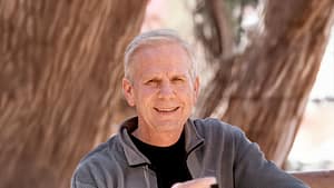 Portrait of Tom smiling outdoors against a natural background of trees