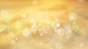 Golden abstract background with soft bokeh lights and translucent glowing orbs, creating a serene, ethereal atmosphere.