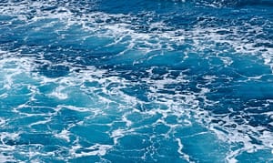 Vivid blue ocean waves with white foam, capturing the dynamic energy and soothing rhythm of the sea.