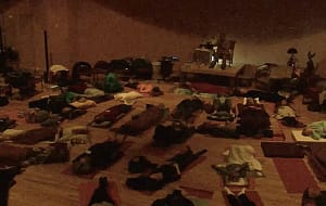 A room filled with lots of people laying on the floor practicing Qigong