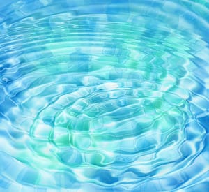 A calming ripple effect on a serene water surface, featuring shades of blue and green that create a soothing, reflective pattern. Perfect for themes of tranquility, healing, and the flow of energy in nature.